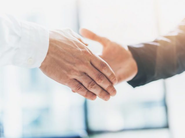 Business partnership meeting. Photo businessmans handshake. Successful businessmen handshaking after good deal. Horizontal, blurred background